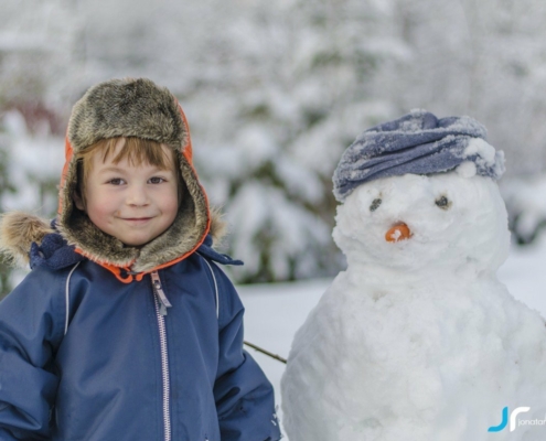 cute boy smiling with snowman