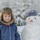cute boy smiling with snowman