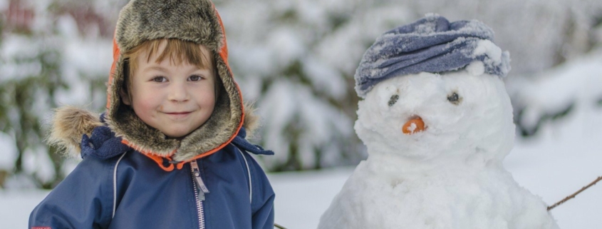 cute boy smiling with snowman